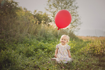 adorable caucasian happy laughing smile  blond little girl holding red baloon 