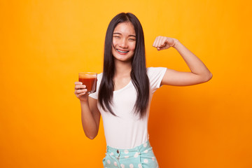 Strong healthy Asian woman with tomato juice.