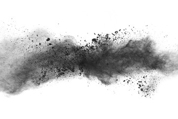 Black powder explosion. The particles of charcoal splatter on white background. Closeup of black...
