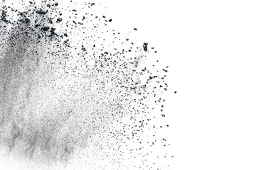 Black powder explosion against white background.Closeup of black dust particles explode isolated on white background.