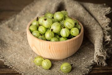 Fresh gooseberry in a wooden bowl.