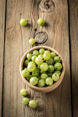 Fresh gooseberry in a wooden bowl.