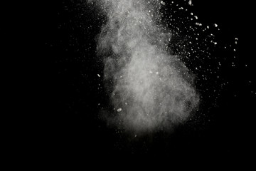 Bizarre forms of of white powder explosion cloud against dark background.Launched white dust splash on black background.