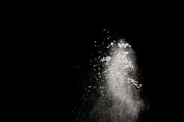 Fototapeta na wymiar Bizarre forms of of white powder explosion cloud against dark background.Launched white dust splash on black background.