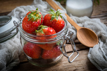 Strawberry in jar on wooden background.