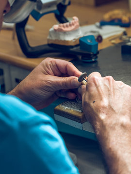 Crop man polishing denture