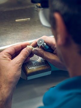 Close up of a man polishing denture