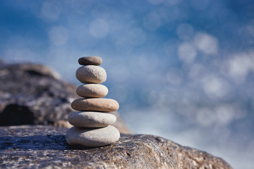 Balanced stone on a peddle beach during sunset.