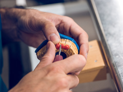 Dental technician polishing teeth