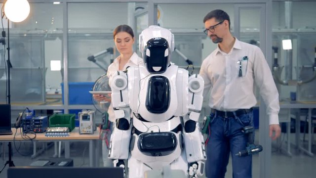People check a robot together.