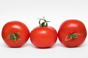 fresh tomatoes close-up with green leaf on white background