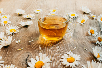Chamomile tea in a glass cup on a wooden table