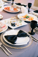 The waiter in uniform with a white towel offers visitors wine in restaurant