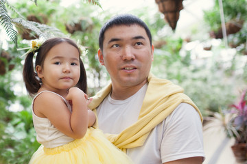 portrait of father and little daughter in botanical garden