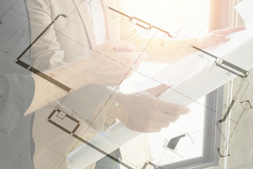 Architects with blueprint in hand discussing new housing project renovation.  City and urban planning.