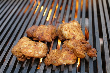 Spicy Chicken grilling over flames
