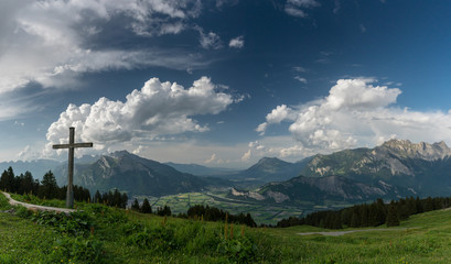 mountain panorama with a gorgeous view of the Swiss Alps and Valleys and a summit cross
