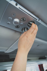 Woman checking air-conditioning system in bus.