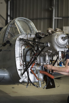 Crop hands repairing plane engine