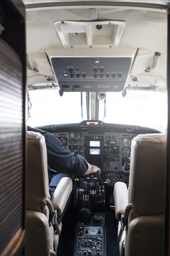 Faceless pilot flying modern aircraft