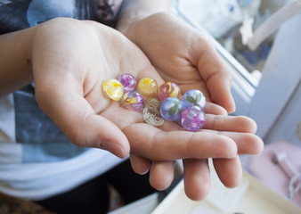 Girls hands keeping epoxy balls with dry flowers inside