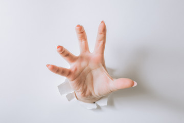girl hand breaks white paper and shows a gesture