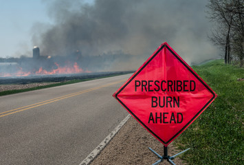 Prescribed Agricultural Burn Area and Sign:  A sign warns motorists of a controlled burn area ahead on a farm in southern Wisconsin.  - obrazy, fototapety, plakaty