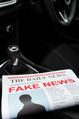Newspaper in a car with the headline fake news