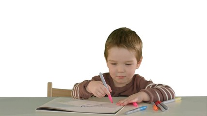 Naklejka premium A son drawing at the table at home on white background isolated
