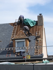 Naklejka premium PLERIN, FRANCE 06 APRIL, 2018: Roofing workers on a roof at Plerin