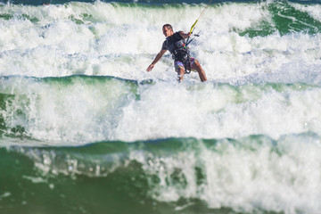 Young athletic man riding kite surf on a sea