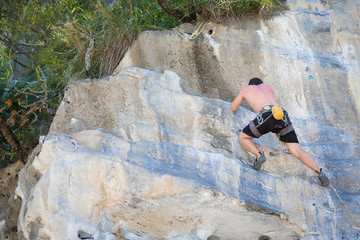 Young man rock climbing on white mountain