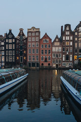 20 MAY 2018 - AMSTERDAM, NETHERLANDS: facades of ancient building above canal on twilight, Amsterdam, Netherlands