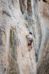 Obraz premium Young woman rock climbing on white mountain