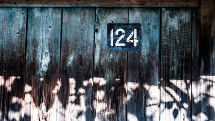 one two four...one hundred twenty-four... plate with the number of the structure. wooden Russia. the wall of the country house.
