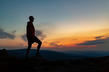 Fototapeta na wymiar Man celebrating sunset looking at view in mountains