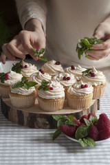 Decorating cupcakes with creamcheese, meringues and cranberries.