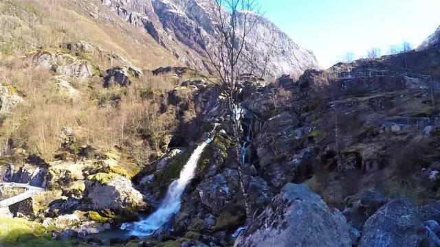 Side view of little waterfall surrounded by rocks at Briksdal glacier in Norway