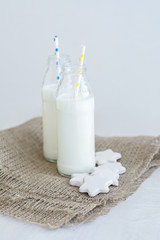 Two bottles of milk and cookies shaped stars