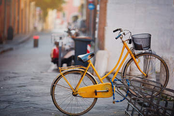 Fototapeta na wymiar Beautiful vintage yellow bicycle on the old Italy street