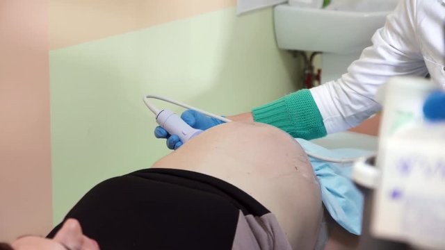 belly of a pregnant girl on ultrasound examination in the doctor's office