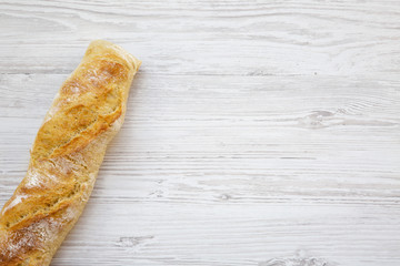 Italian baguette on white wooden background, top view. From above. Copy space.