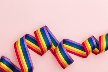 Gay pride LGBT rainbow ribbon on pink background