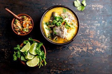 CHILEAN FOOD. Fish soup CALDILLO DE CONGRIO served in clay bowl, top view. copy space