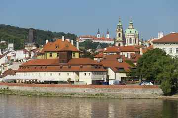 Spring Prague St. Nicholas' Cathedral with the Lesser Town above River Vltava in the sunny Day,...