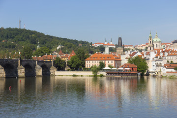 Naklejka premium Spring Prague St. Nicholas' Cathedral with the Lesser Town above River Vltava in the sunny Day, Czech Republic