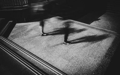 People in motion on the exit of underground pedestrian road. Blurred long exposure image.
