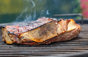 Side view of a grilled beef rib on a barbecue grill