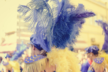 Unidentified blurry carnival dancer on street parade outdoors background. Back view unrecognizable silhouette of joyful dance performers