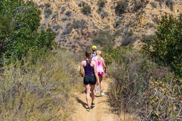 Obraz premium Family hike down into valley on warm summer morning in Southern California mountains